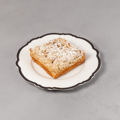 Square Danish with Apple Crumble on a decorative plate with powdered sugar against a grey background