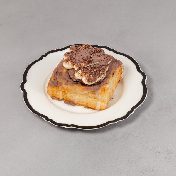 Small dish with a piece of bread topped with a slice of meat on a gray background