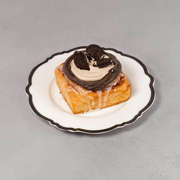Small pastry with chocolate cream on a white plate against a gray background