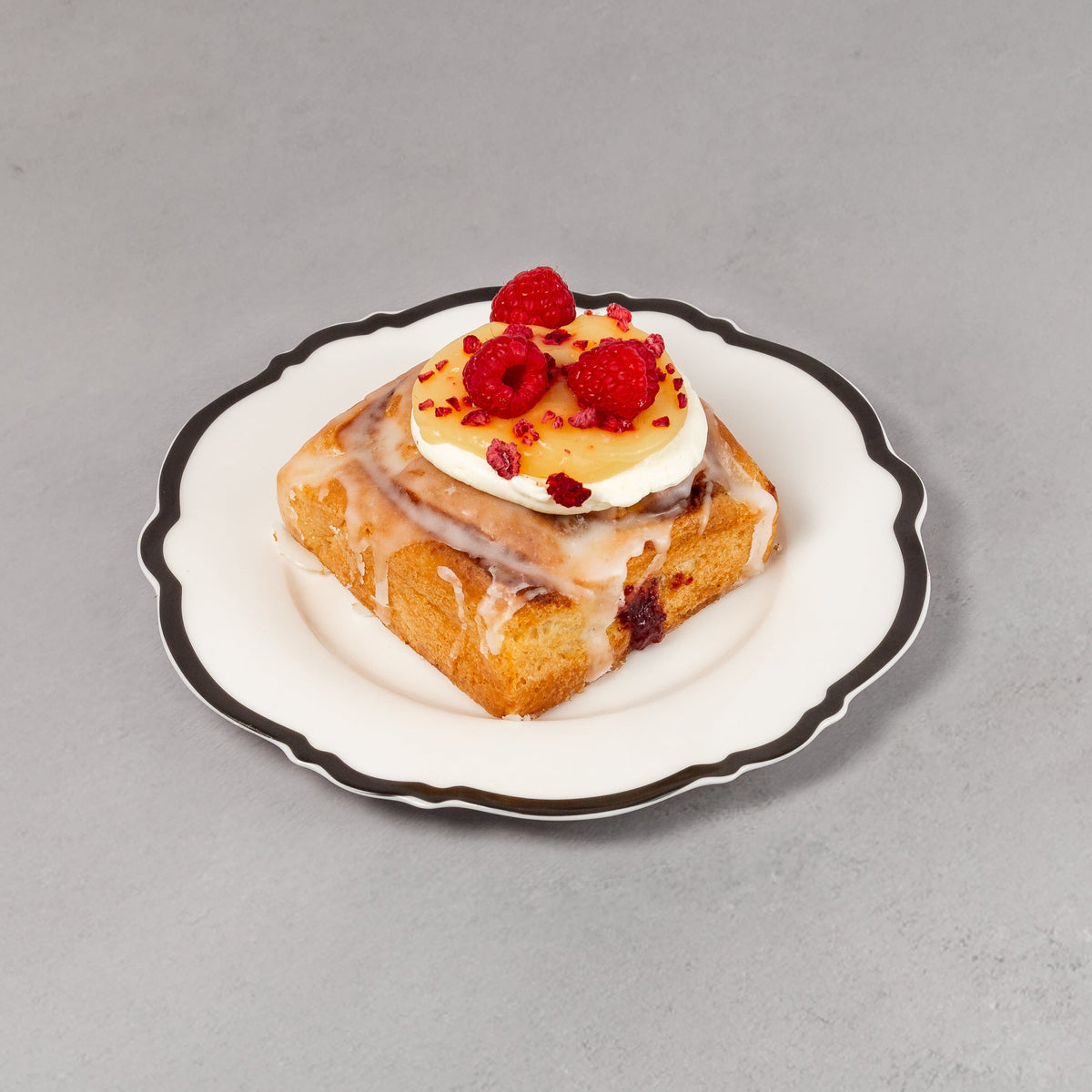 Small dessert on a decorative plate with red berries against a gray background