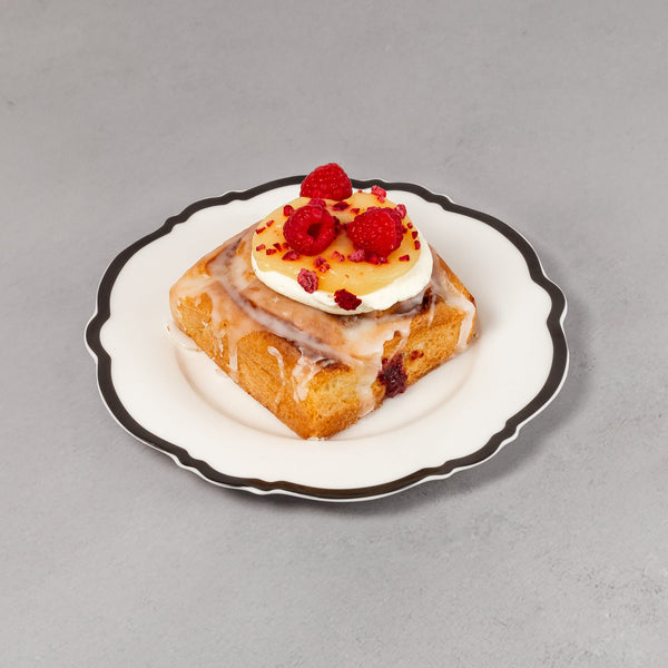 Small dessert on a decorative plate with red berries against a gray background