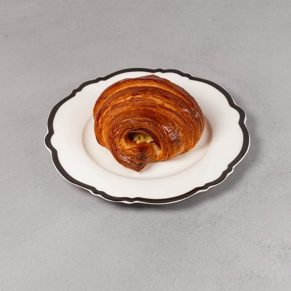 Pastries on a white plate with black rim on a gray background